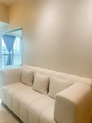 a white couch in a room with a window at Uptown District Stay in Manila