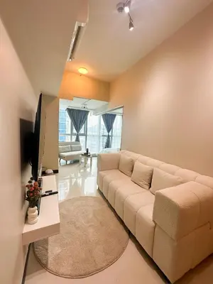 a living room with a couch and a tv at Uptown District Stay in Manila