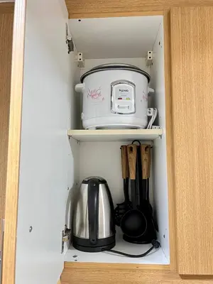 a cabinet with a coffee maker and a tea kettle at OASIS by JK Suites in Manila