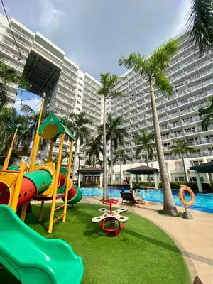 a playground in a resort with a large building at OASIS by JK Suites in Manila