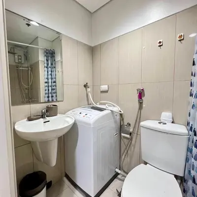 a bathroom with a washing machine and a sink at OASIS by JK Suites in Manila