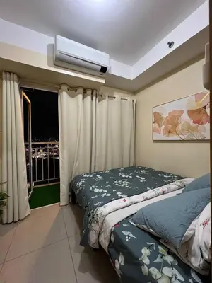 a bedroom with a bed and a window at SKYLINE by JK Suites in Manila
