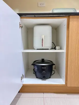 a cabinet with a slow cooker and a toaster at SKYLINE by JK Suites in Manila