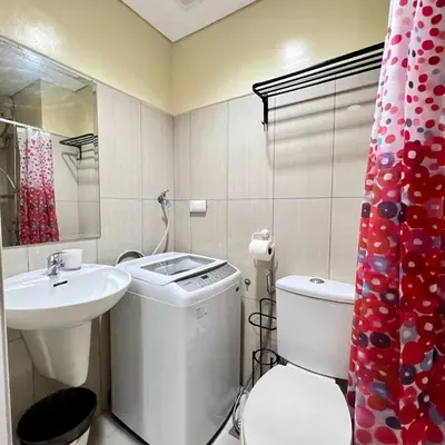 a white bathroom with a sink and a toilet at SKYLINE by JK Suites in Manila