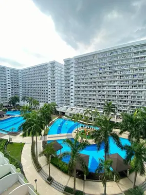 a large apartment building with a large swimming pool at SKYLINE by JK Suites in Manila