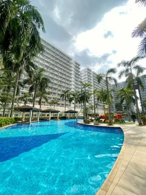 a large swimming pool in front of a large building at SKYLINE by JK Suites in Manila