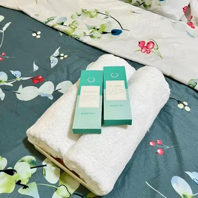 two green certificates sitting on top of a bed at SKYLINE by JK Suites in Manila