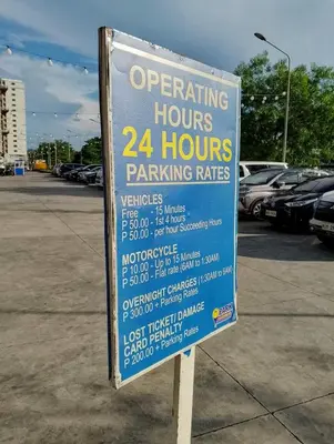 a parking sign in a parking lot with cars parked at The Ren Suite Facing Sunrise or City View in Manila