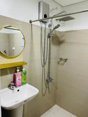 a bathroom with a shower and a sink and a mirror at The Ren Suite Facing Sunrise or City View in Manila