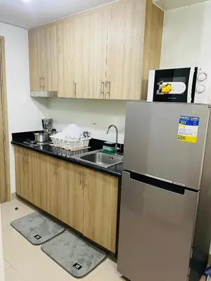 a kitchen with a sink and a refrigerator at The Ren Suite Facing Sunrise or City View in Manila