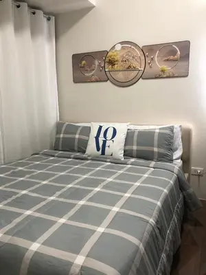 a bedroom with a bed with a blue and white blanket at Corner 1Bedroom with Unparalleled Views #5235 in Manila