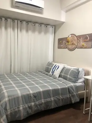a bedroom with a bed with a blue and white blanket at Corner 1Bedroom with Unparalleled Views #5235 in Manila