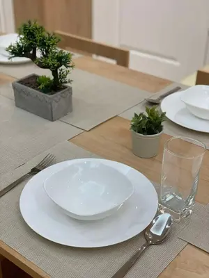 a table with a white plate and a fork and spoon at Supreme Luxury 2BR Condo - Azure Urban Resort Residences near Manila Airport in Manila