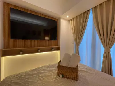 a bedroom with a bed with a tv on the wall at Supreme Luxury 2BR Condo - Azure Urban Resort Residences near Manila Airport in Manila