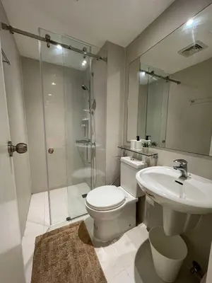 a bathroom with a toilet and a shower and a sink at Supreme Luxury 2BR Condo - Azure Urban Resort Residences near Manila Airport in Manila