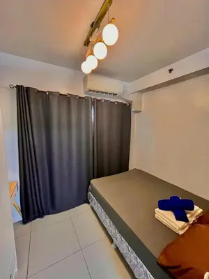 a small bedroom with a bed and a window at Shore 8109 onebedroomwbalcony in Manila