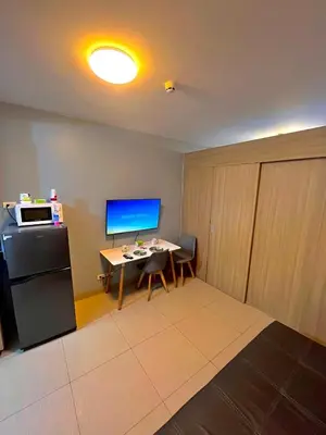 a room with a desk with a computer and a refrigerator at Shore 8109 onebedroomwbalcony in Manila