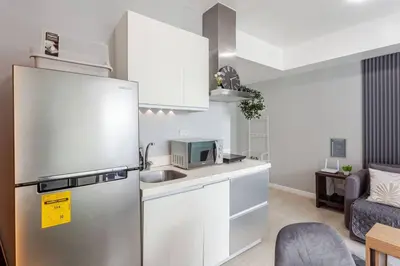 a kitchen with a stainless steel refrigerator and a microwave at Cee Staycation in the City - Azure Maui Penthouse in Manila