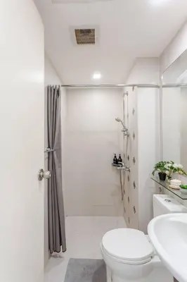 a white bathroom with a shower and a toilet at Cee Staycation in the City - Azure Maui Penthouse in Manila
