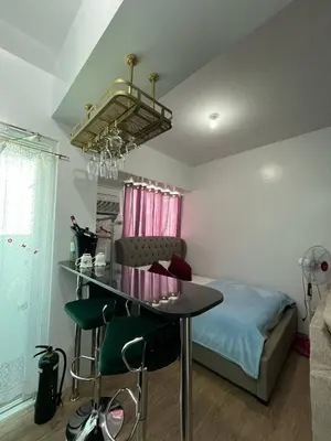 a room with a table and a bed and a room with a bed at Anuva Condo Staycation in Manila