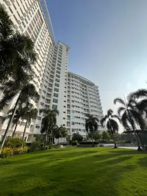 a large building with palm trees in a park at Anuva Condo Staycation in Manila