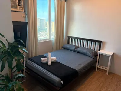 a small bed in a room with a window at Anuva Condo Staycation in Manila