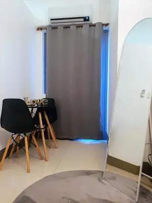 a room with a mirror and a table and a curtain at Condo with Mall in Manila