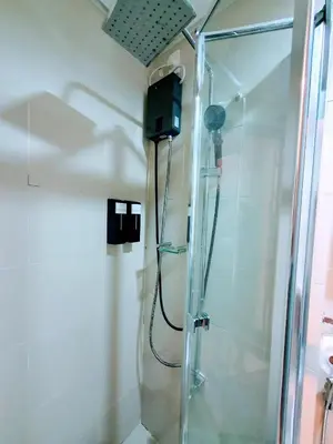 a shower in a bathroom with a glass shower stall at Condo with Mall in Manila