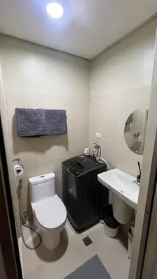 a bathroom with a toilet and a sink at Condo with Mall in Manila