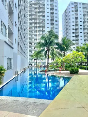 a swimming pool in a city with tall buildings at Shore 607 A bayview moa in Manila