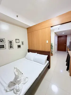 a bedroom with a bed with a wooden headboard at Zeth's Place at Shell Residences Near MOA and NAIA in Manila