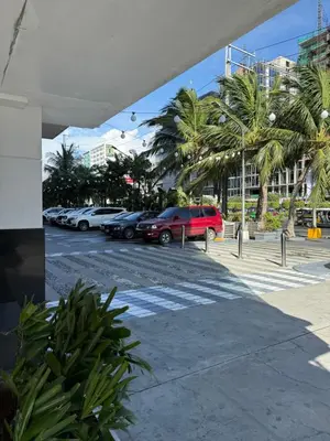 a parking lot with parked cars and palm trees at Zeth's Place at Shell Residences Near MOA and NAIA in Manila