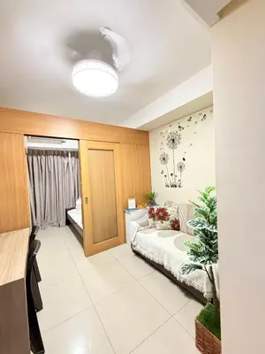 a room with a couch and a bed in it at Zeth's Place at Shell Residences Near MOA and NAIA in Manila