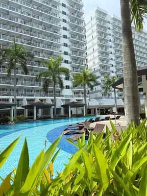 a swimming pool in front of a large apartment building at Zeth's Place at Shell Residences Near MOA and NAIA in Manila