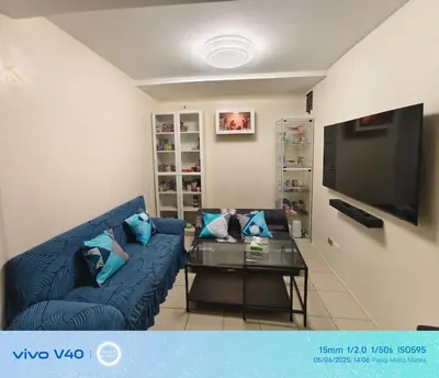 a living room with a blue couch and a table at FamBnb in Manila