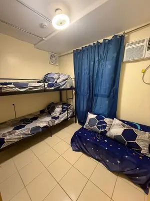 a room with two bunk beds and a blue curtain at FamBnb in Manila