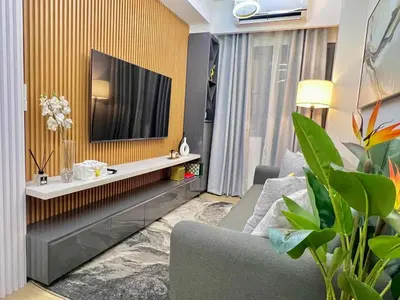 a living room with a couch and a tv on a wall at dream horizon staycation in Manila