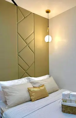 a bedroom with a bed with white sheets and gold pillows at dream horizon staycation in Manila