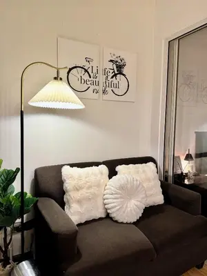 a living room with a brown couch with white pillows at Arcadia Suites Manila at Acqua in Manila