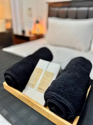 a tray with black towels on a bed at Arcadia Suites Manila at Acqua in Manila