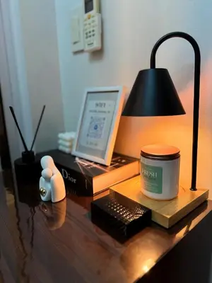 a desk with a laptop computer and a lamp at Arcadia Suites Manila at Acqua in Manila