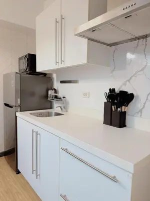 a white kitchen with a sink and a refrigerator at Arcadia Suites Manila at Acqua in Manila