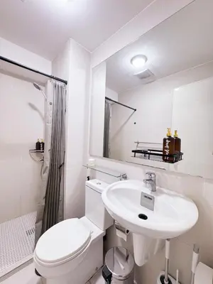 a white bathroom with a toilet and a sink at Arcadia Suites Manila at Acqua in Manila