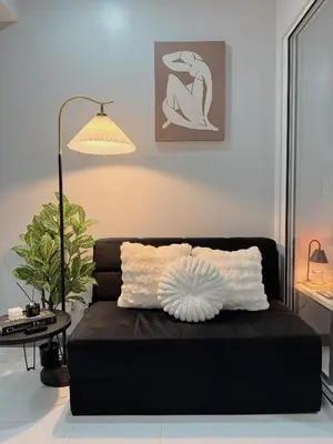 a black couch in a living room with a lamp at Arcadia Suites Manila at Acqua in Manila