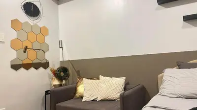 a bedroom with a bed and a chair and a mirror at 2243 Taguig Condo Near Airport and BGC in Manila