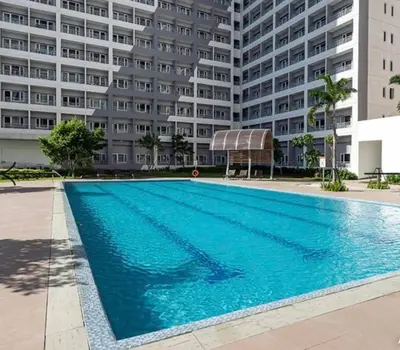 a swimming pool in front of a large building at 2243 Taguig Condo Near Airport and BGC in Manila