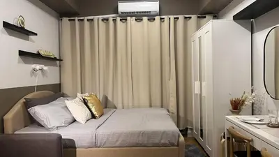 a small bedroom with a bed and a curtain at 2243 Taguig Condo Near Airport and BGC in Manila