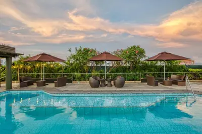 a swimming pool with chairs and umbrellas at Newport Stay by Runway Manila & Attractions in Manila