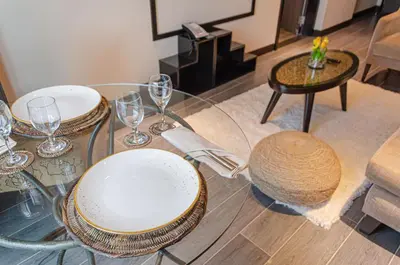 a glass table with plates and wine glasses on it at Newport Stay by Runway Manila & Attractions in Manila
