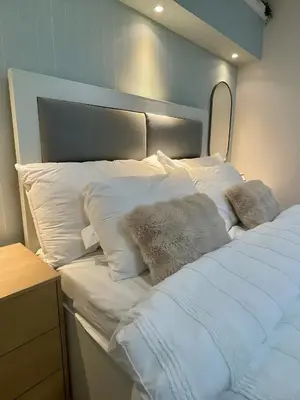a bed with white sheets and pillows on it at Stad en Thuis - Mckinley Hill, Taguig in Manila